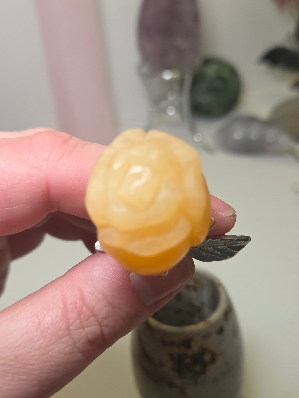 Orange calcite crystal rose carving on a stem