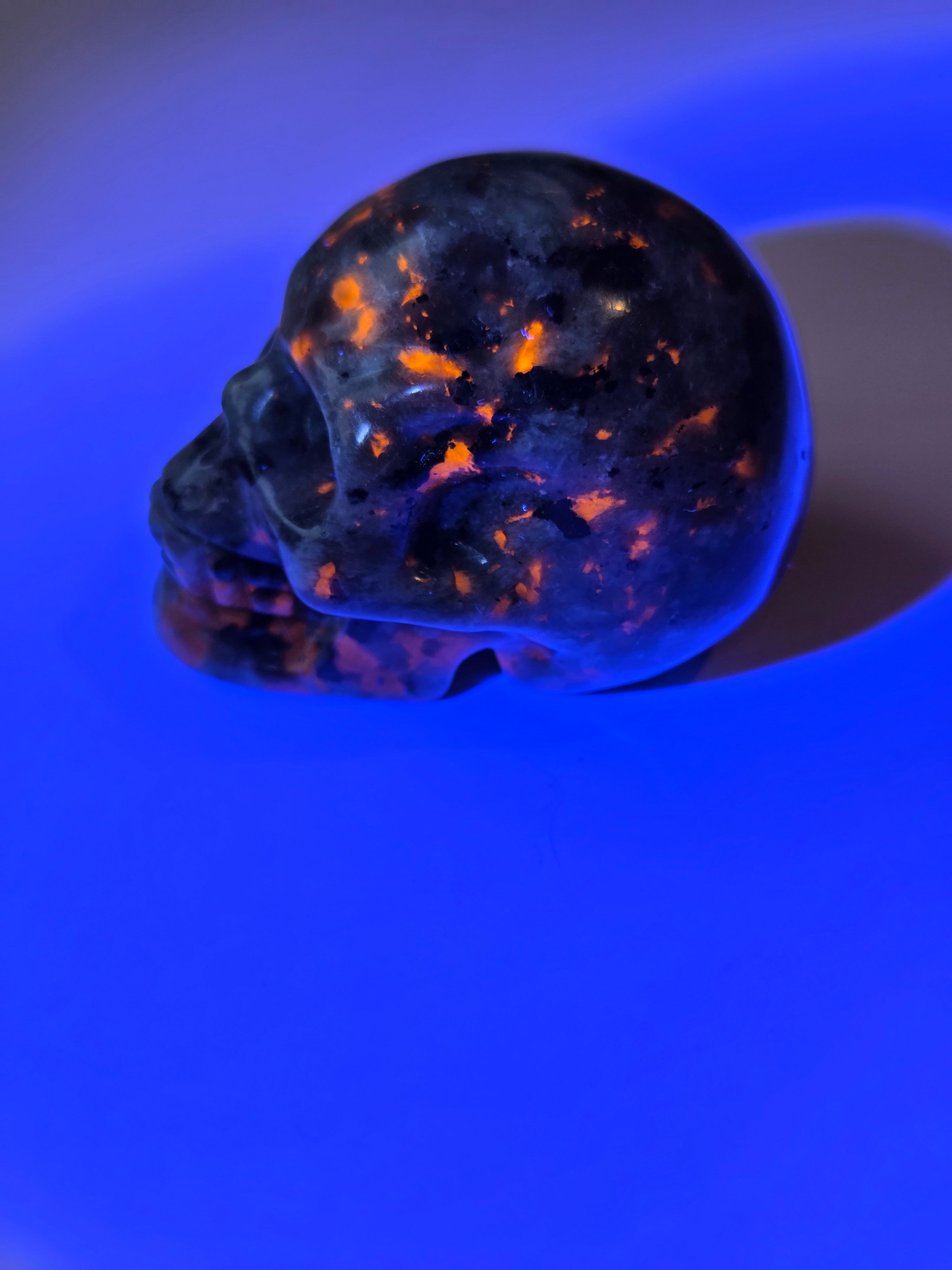Yooperlite crystal skull carving with orange uv