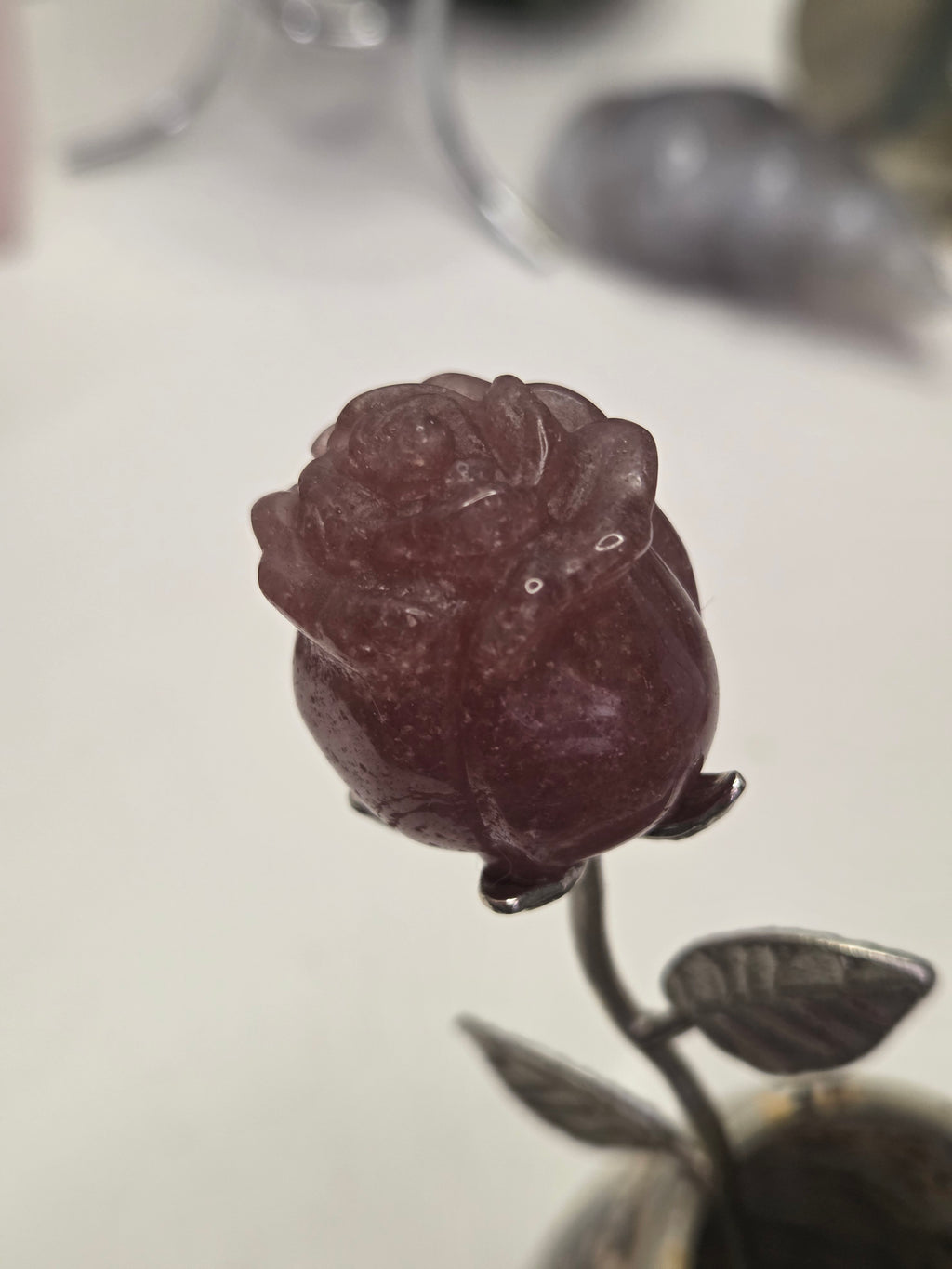 Strawberry quartz crystal rose carving on a stem