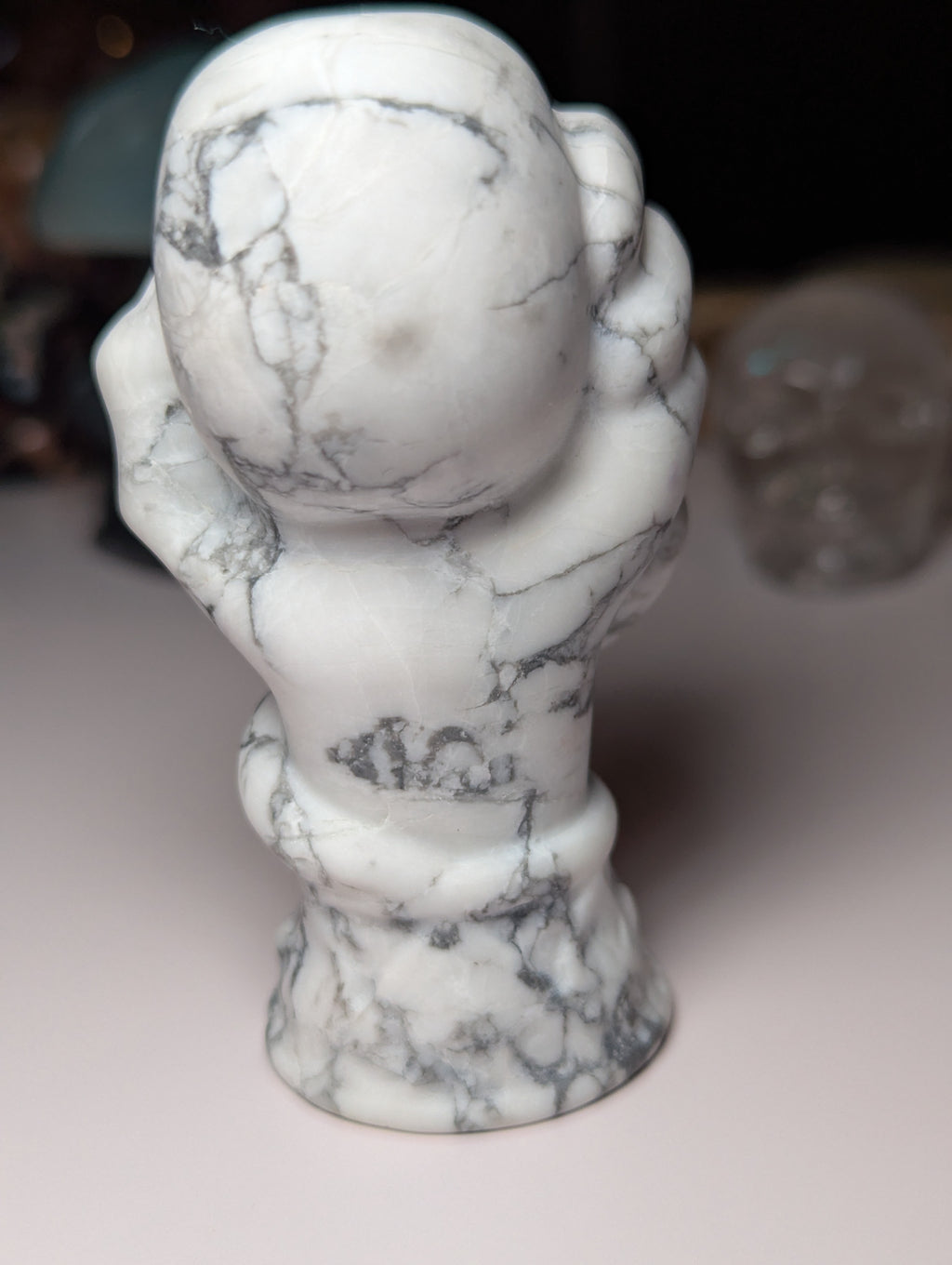 Howelite crystal hand holding skull carving