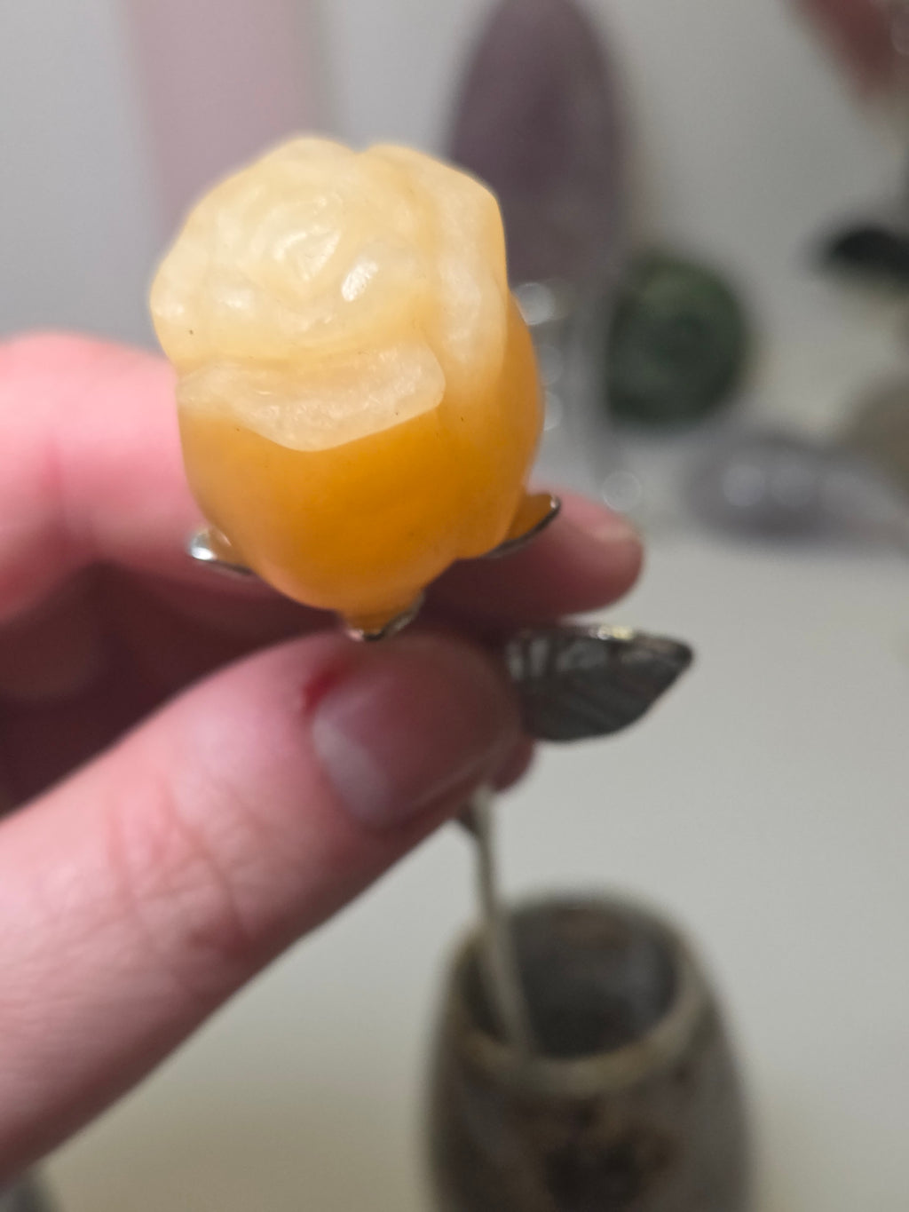 Orange calcite crystal rose carving on a stem