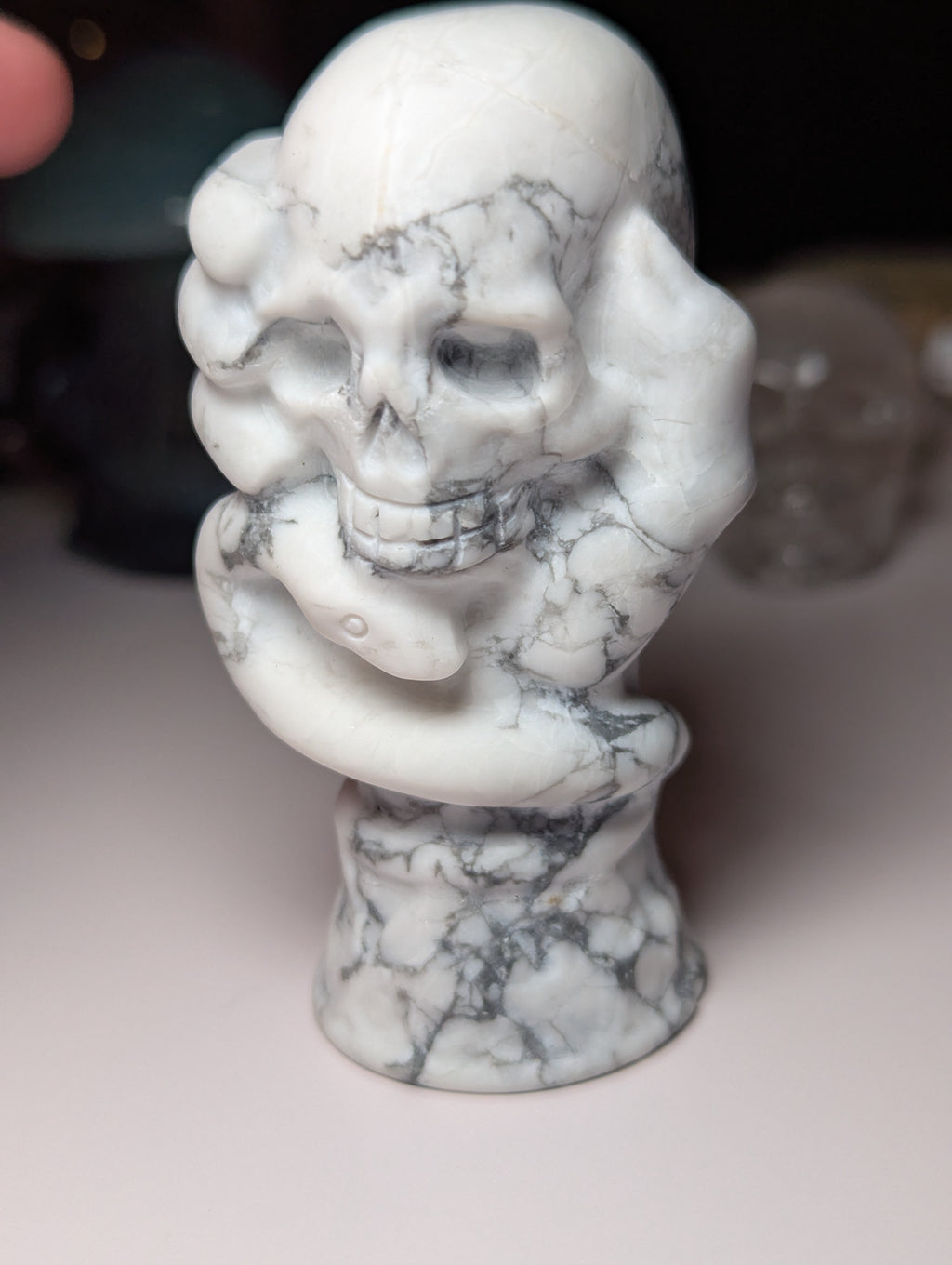 Howelite crystal hand holding skull carving