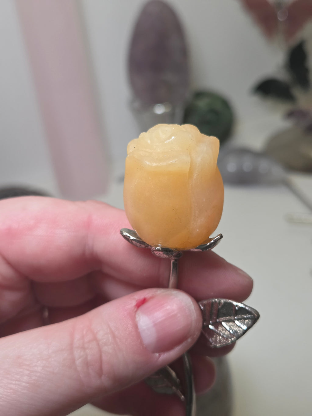 Orange calcite crystal rose carving on a stem