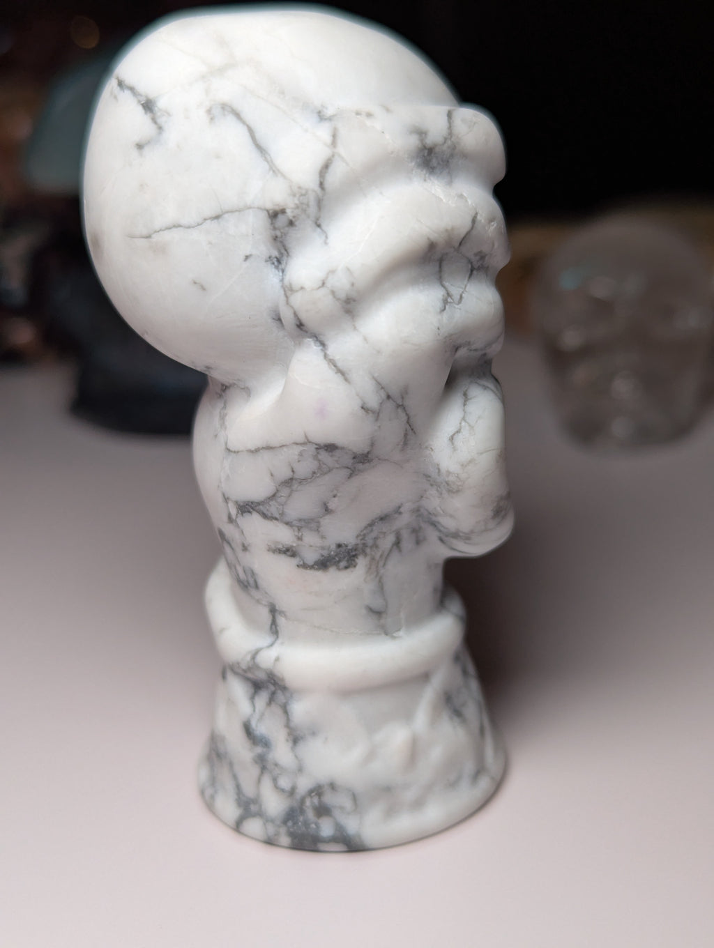 Howelite crystal hand holding skull carving