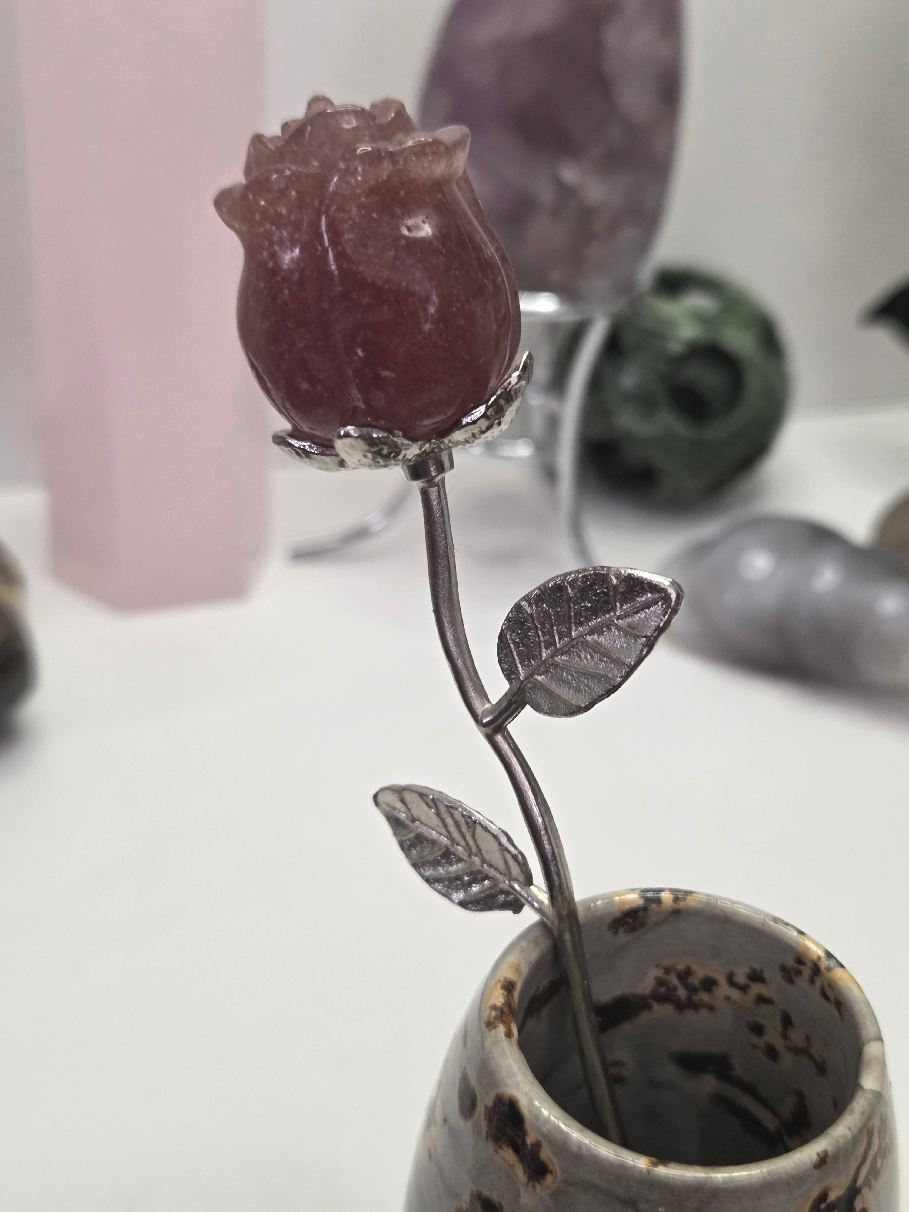 Strawberry quartz crystal rose carving on a stem