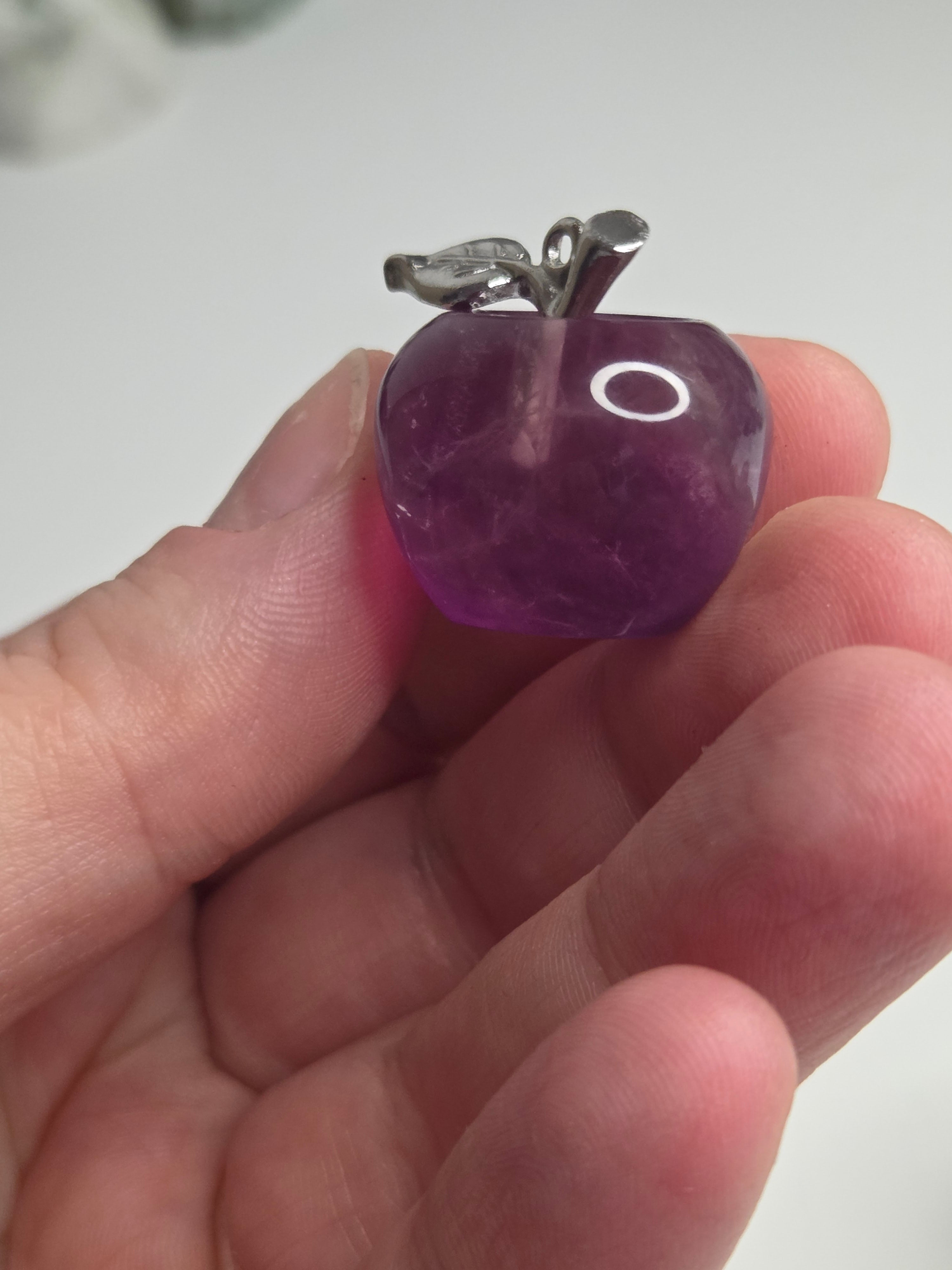 Purple flourite crystal apple carving could be made into a pendant