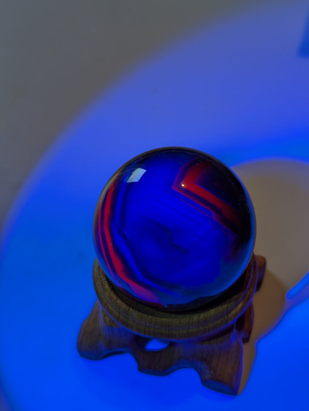 Black flourite crystal sphere with red UV with stand