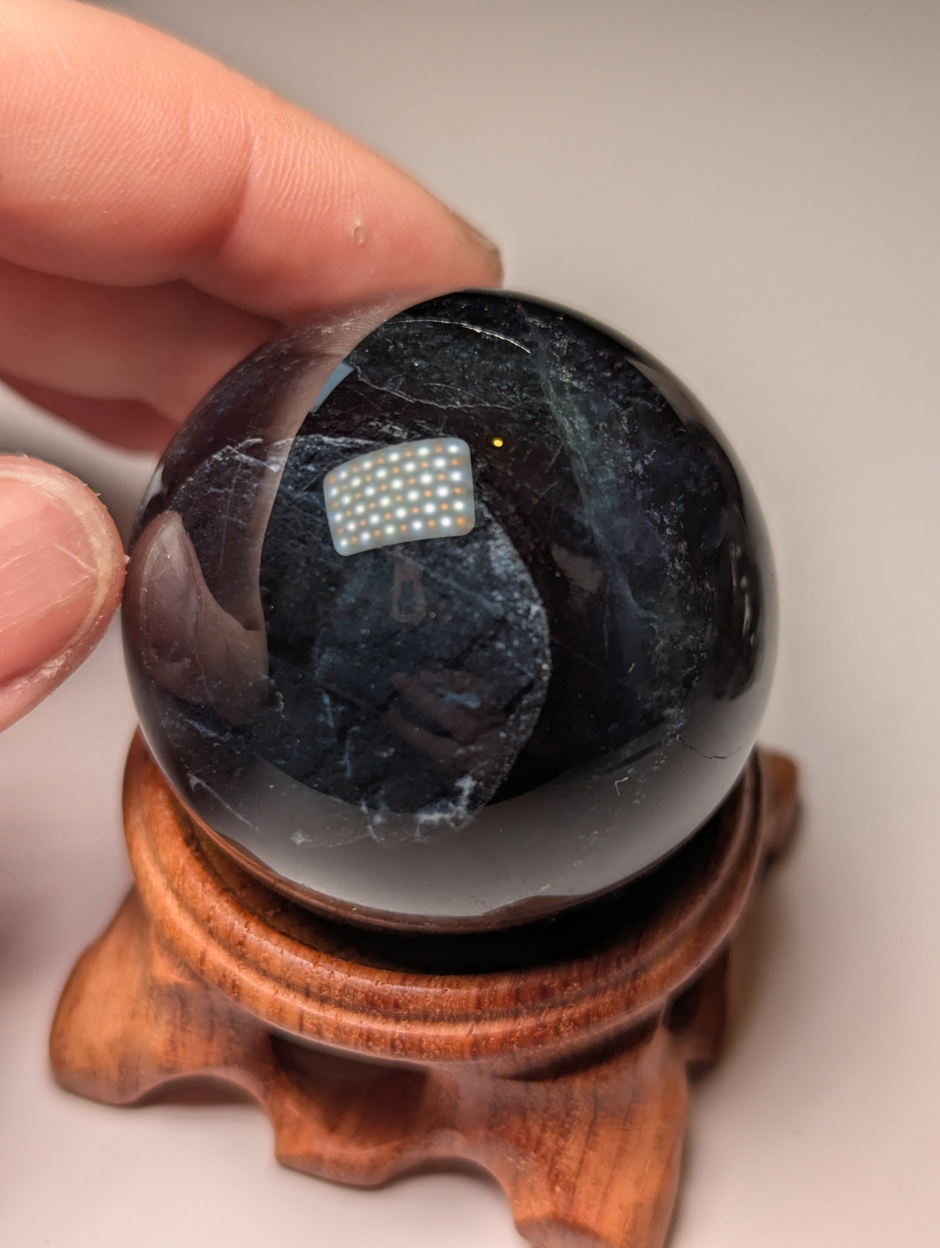 Black flourite crystal sphere with red UV with stand