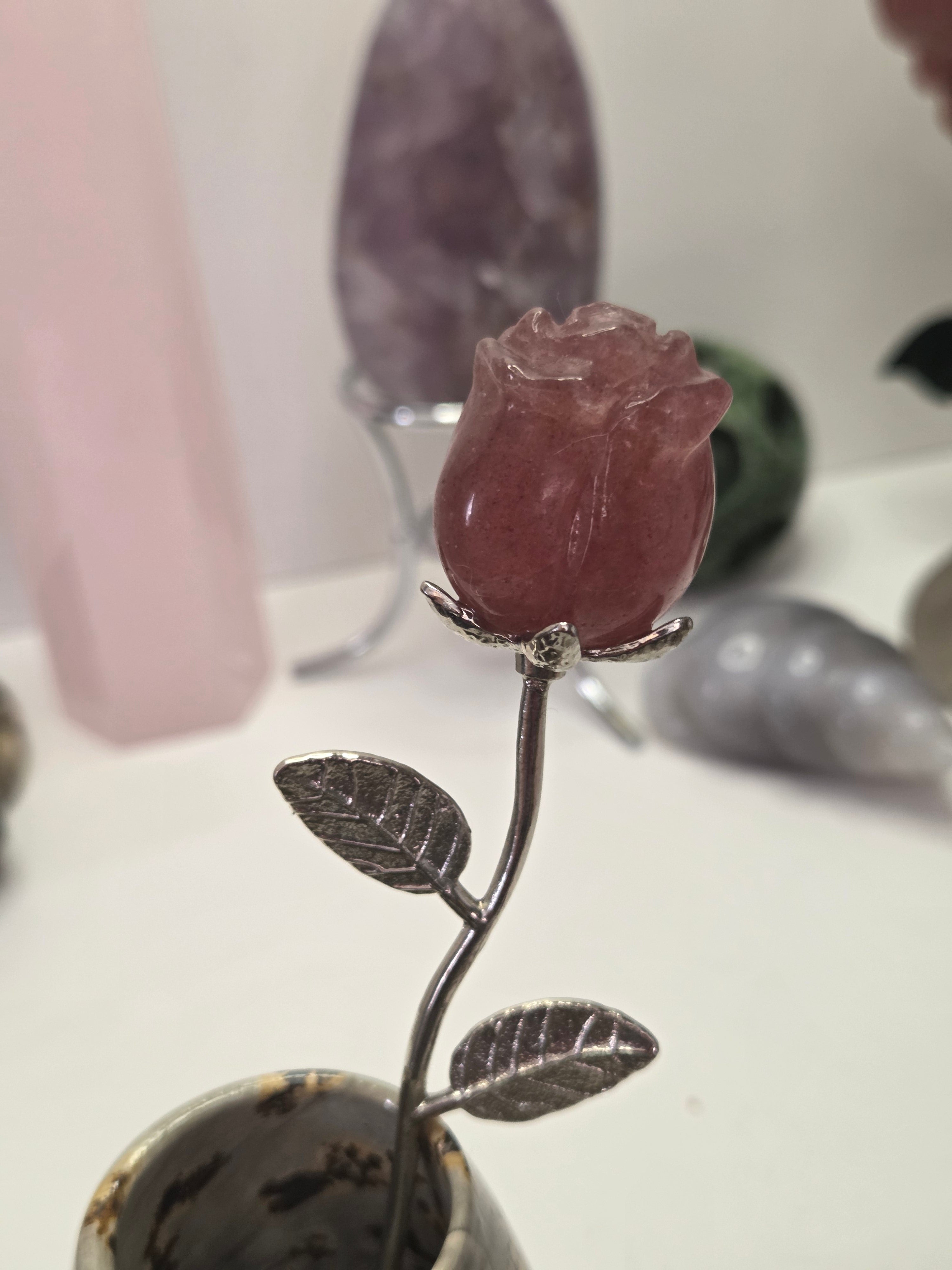 Strawberry quartz crystal rose carving on a stem
