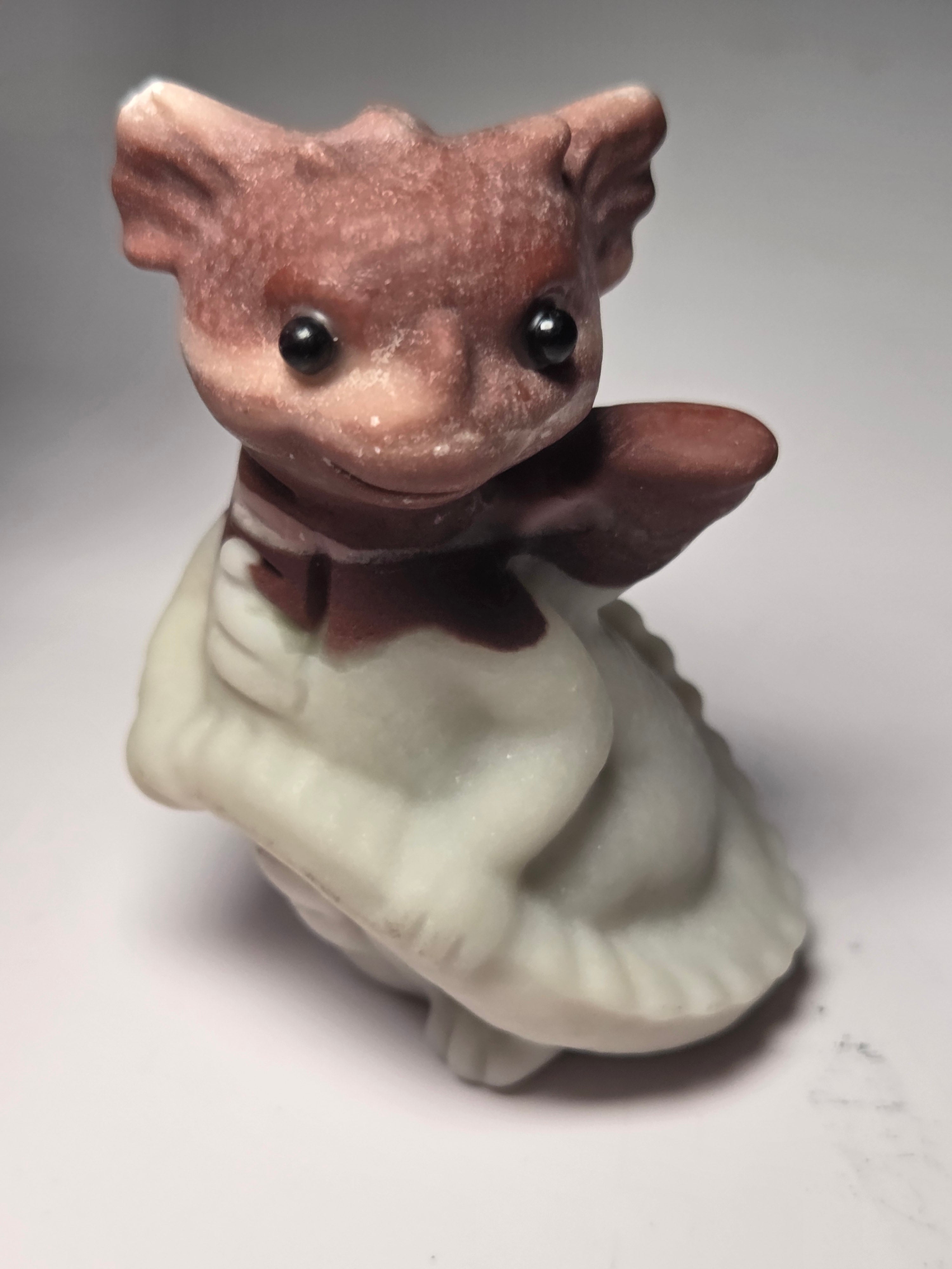 Baby dragon holding tail