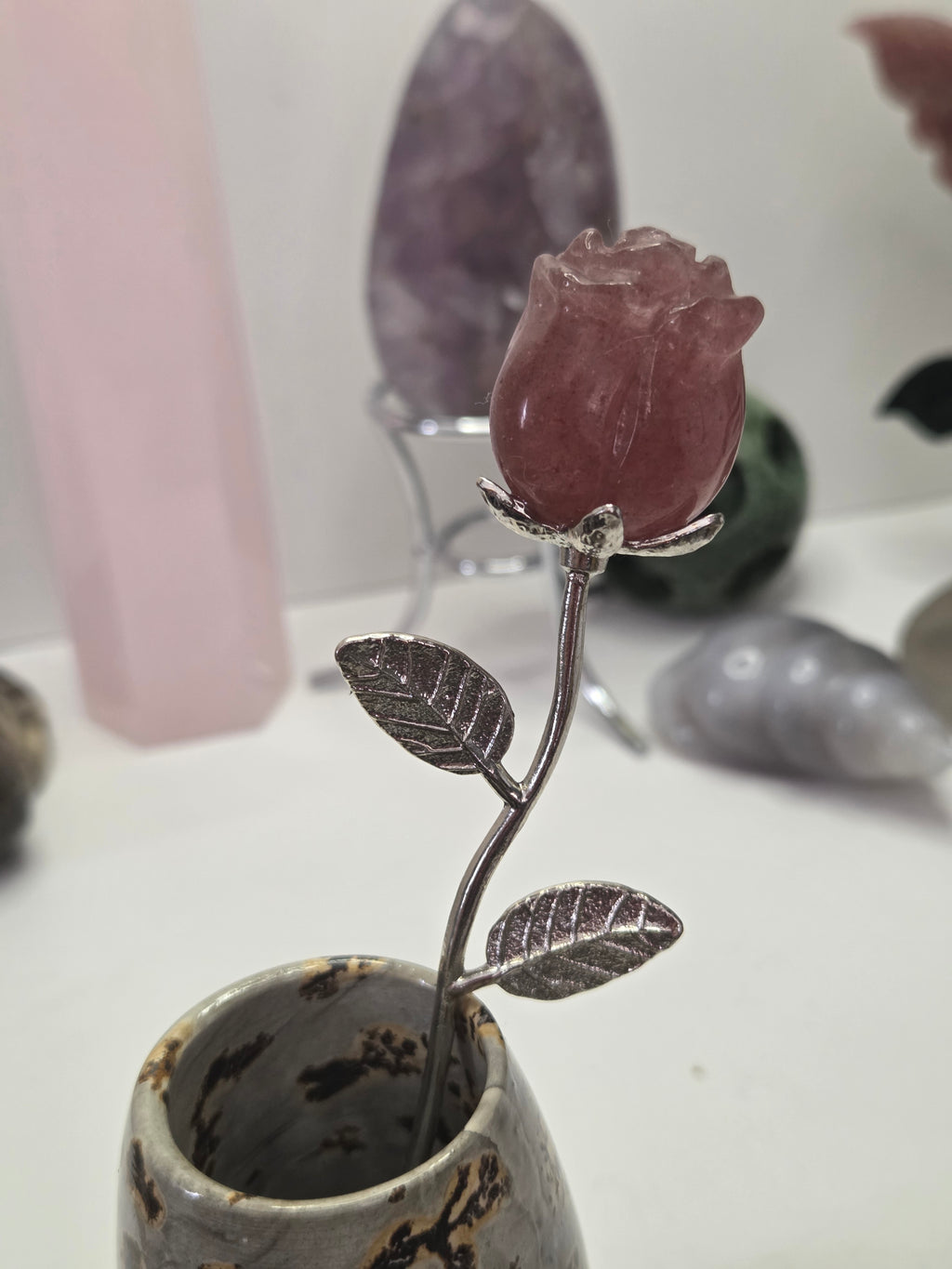 Strawberry quartz crystal rose carving on a stem