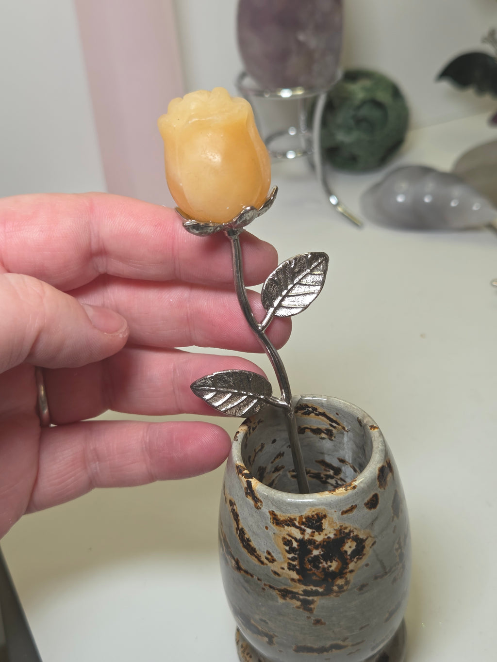 Orange calcite crystal rose carving on a stem