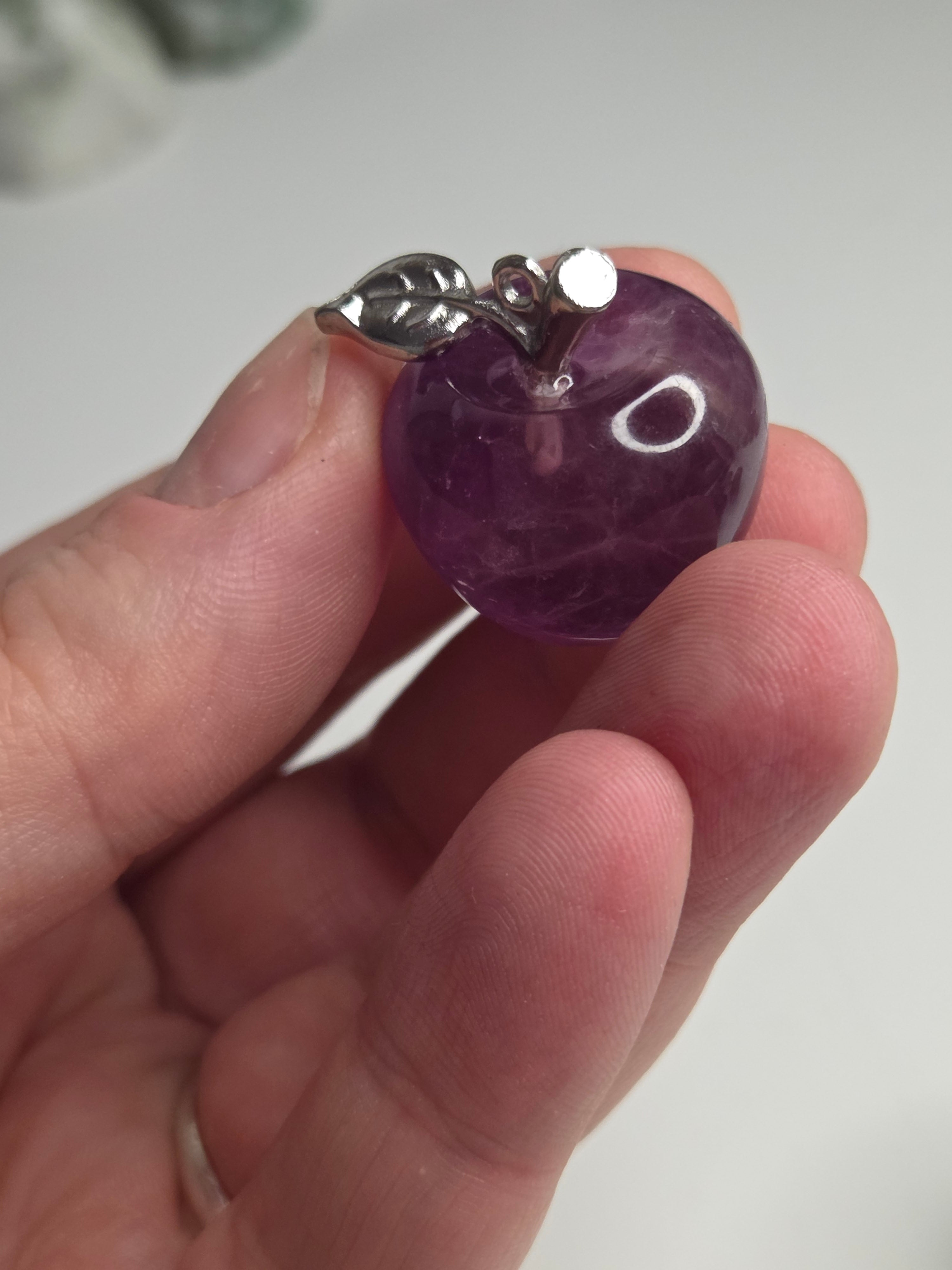 Purple flourite crystal apple carving could be made into a pendant