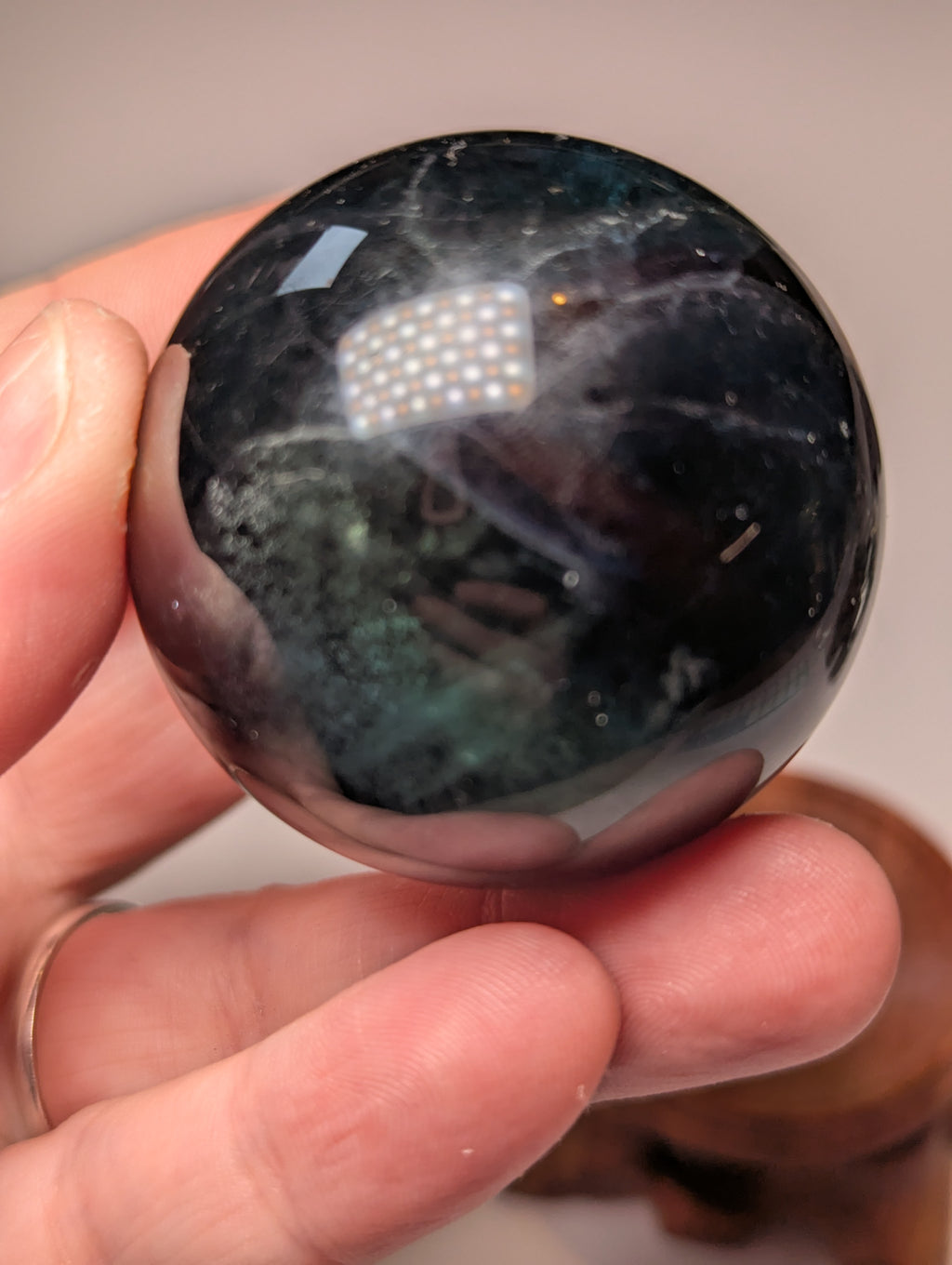 Black flourite crystal sphere with red UV with stand