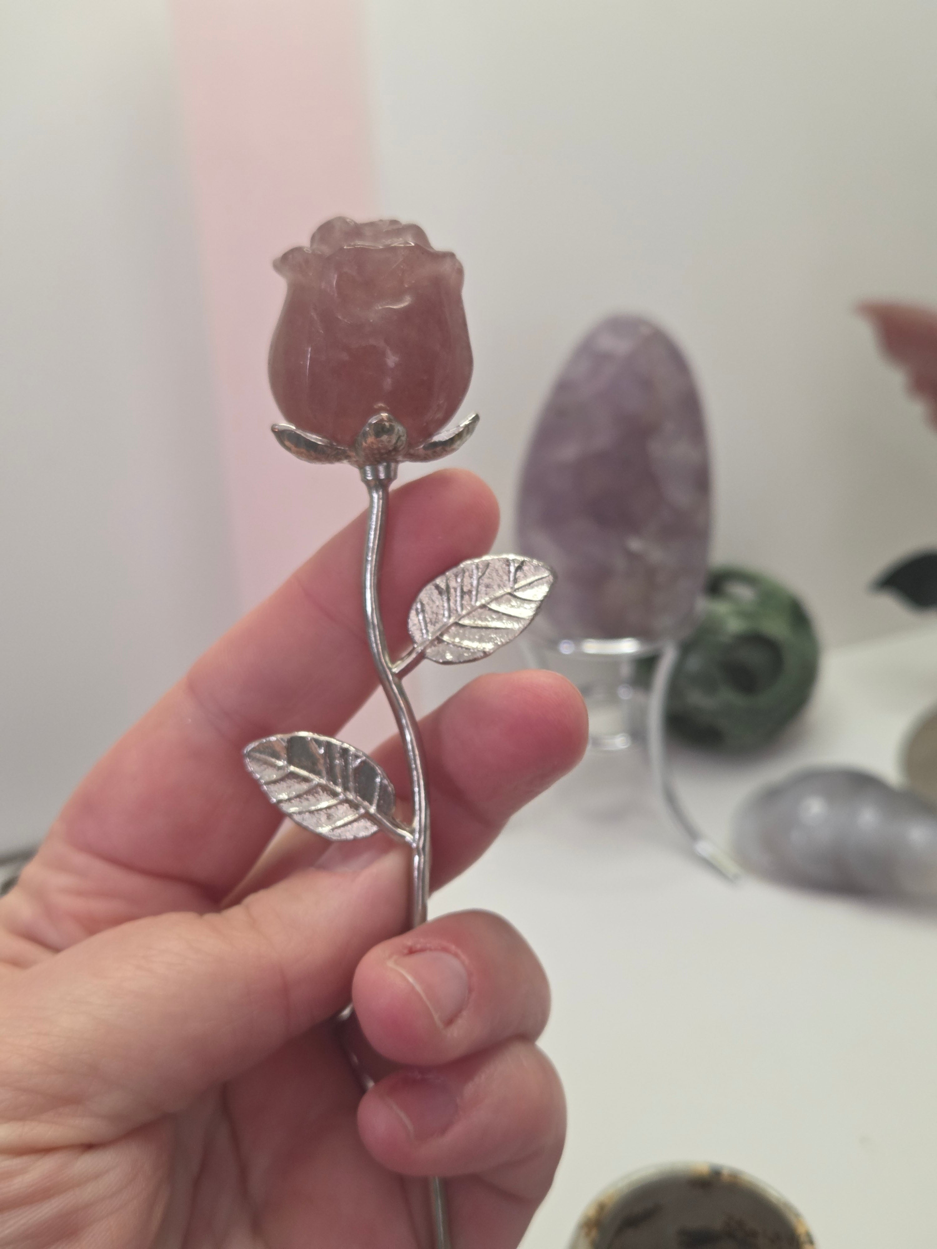Strawberry quartz crystal rose carving on a stem