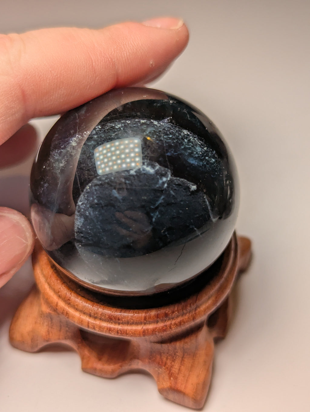 Black flourite crystal sphere with red UV with stand