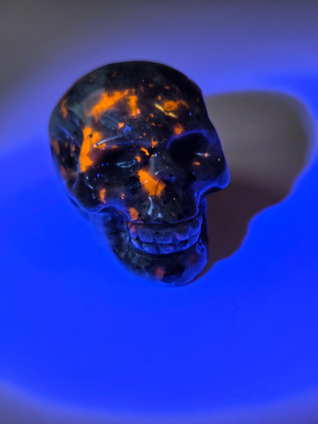 Yooperlite crystal skull carving with orange uv