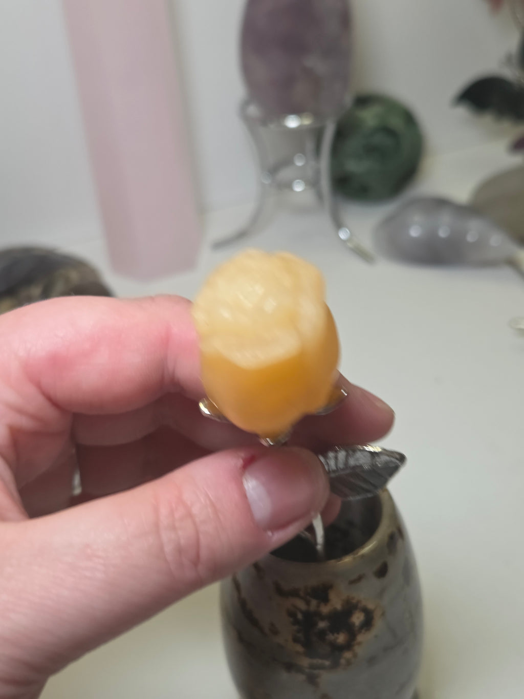 Orange calcite crystal rose carving on a stem