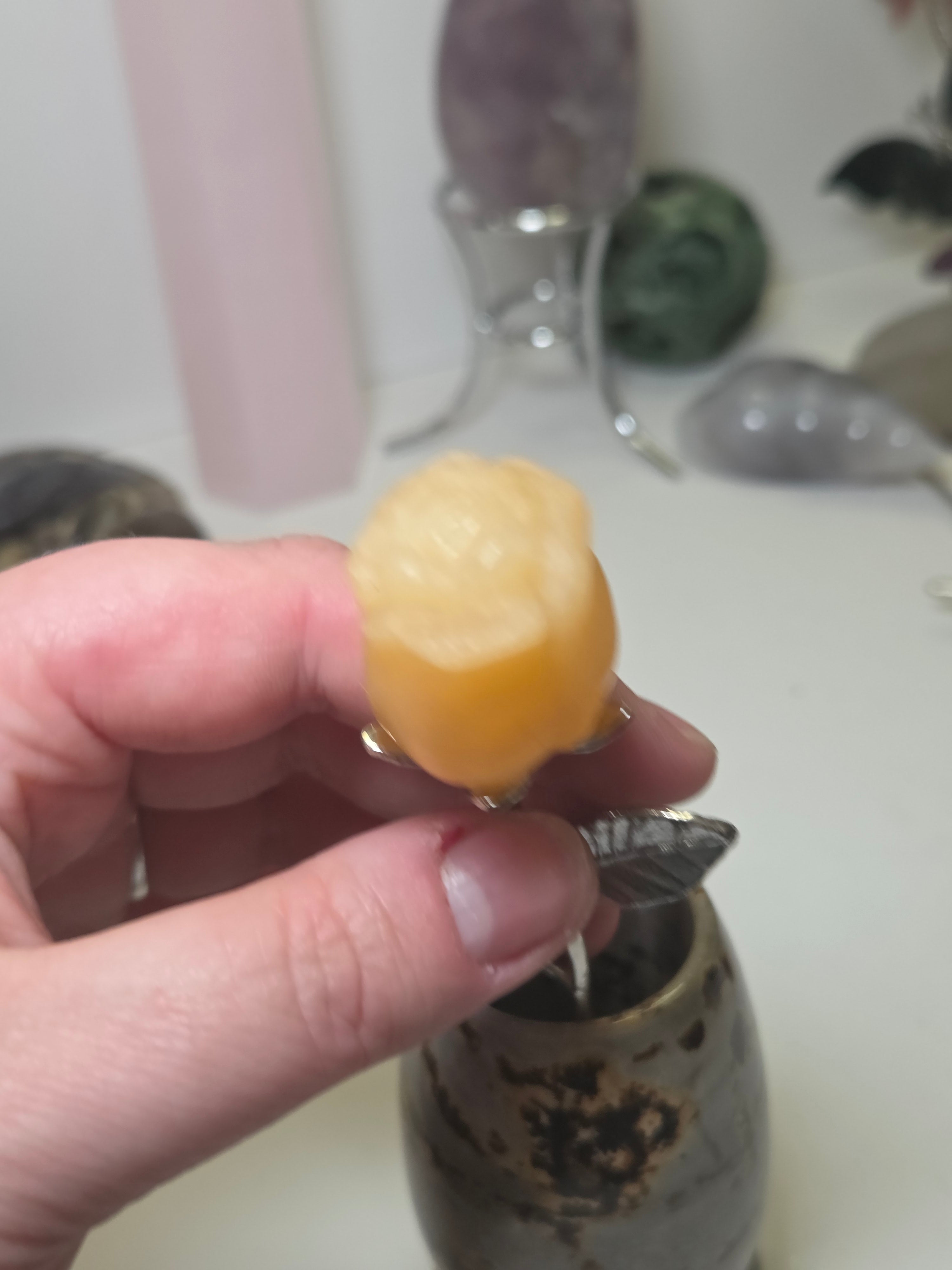 Orange calcite crystal rose carving on a stem