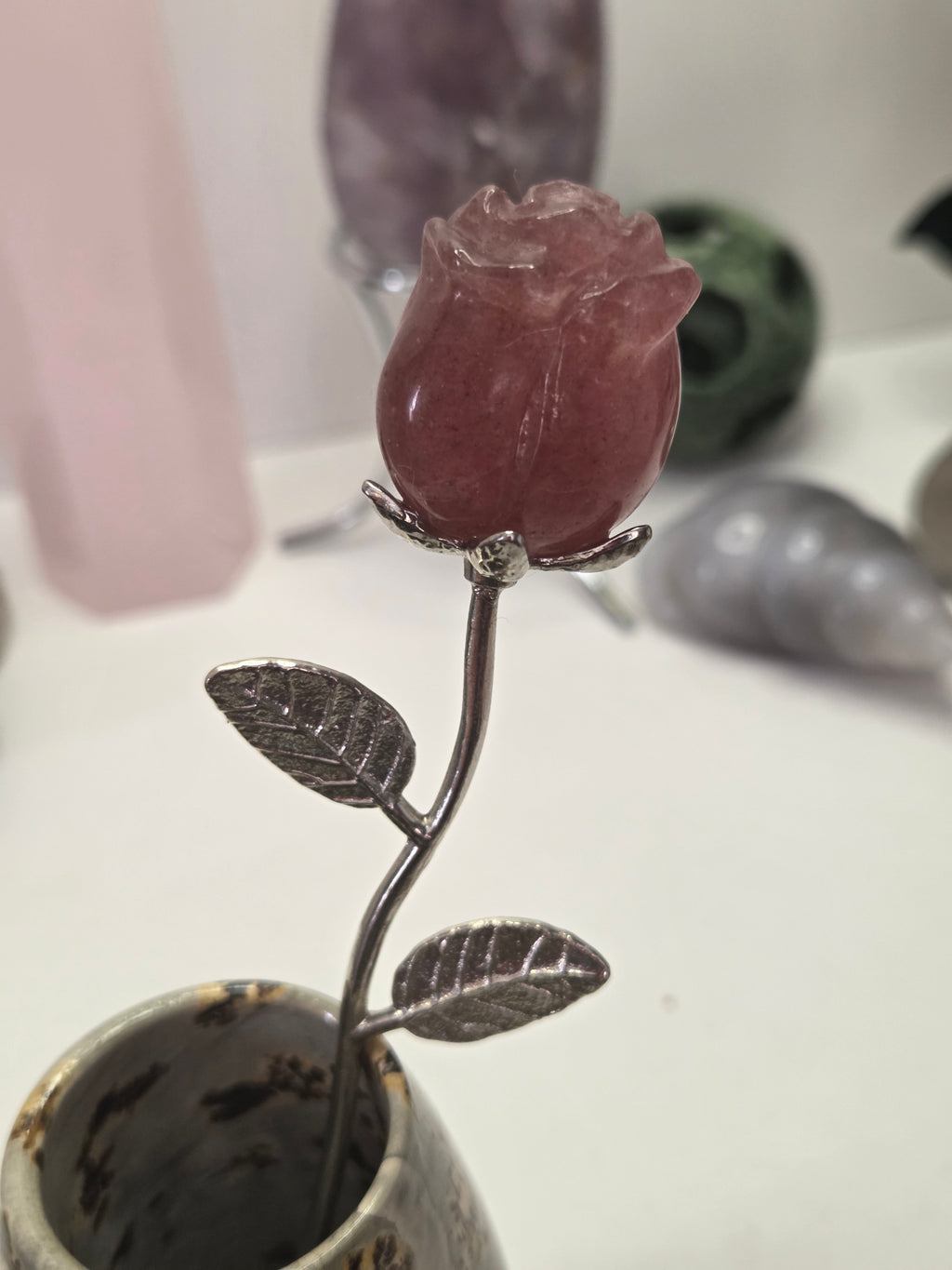 Strawberry quartz crystal rose carving on a stem
