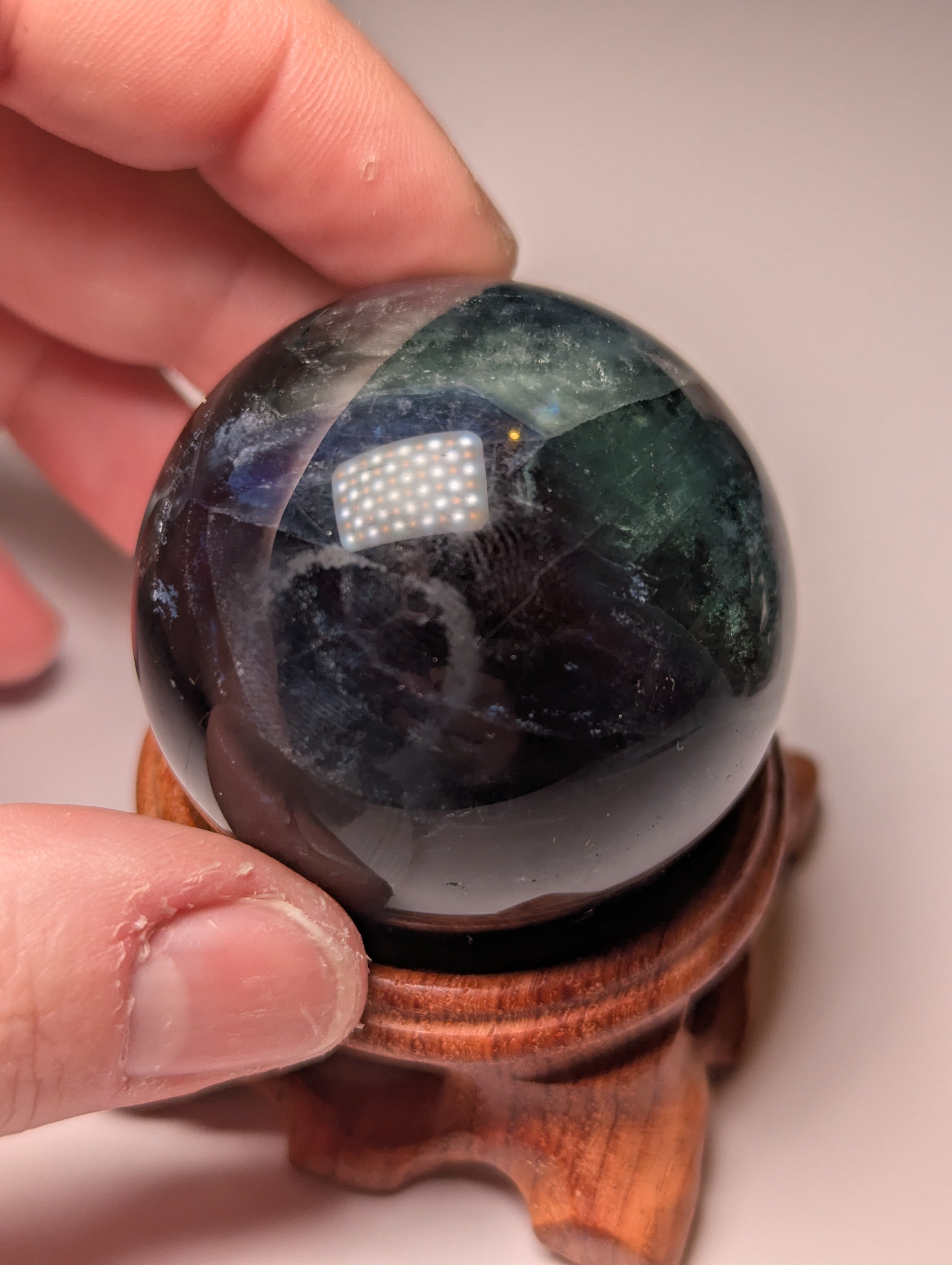 Black flourite crystal sphere with red UV with stand