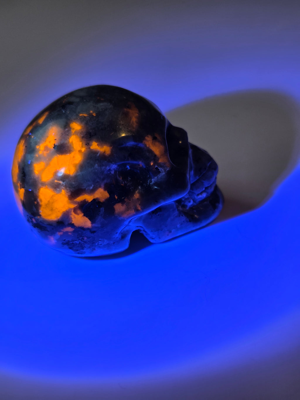 Yooperlite crystal skull carving with orange uv