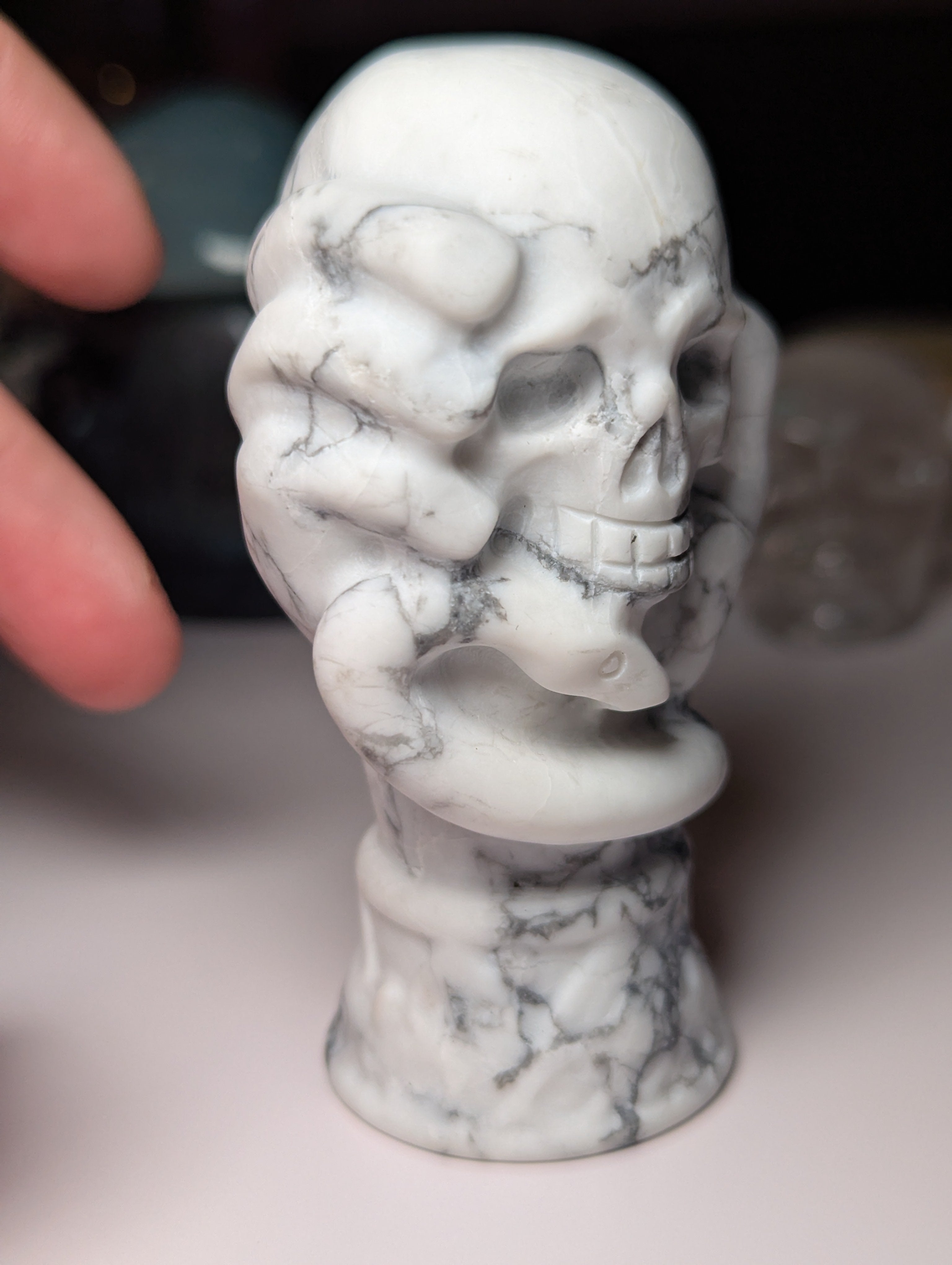 Howelite crystal hand holding skull carving